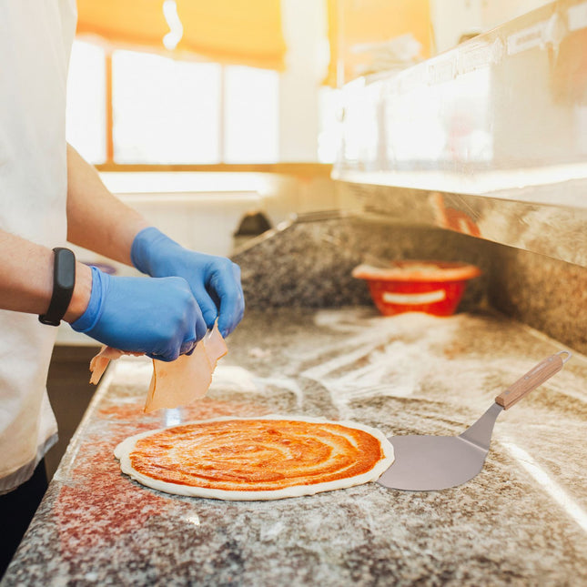 Lopata na pizzu se světle hnědou dřevěnou rukojetí